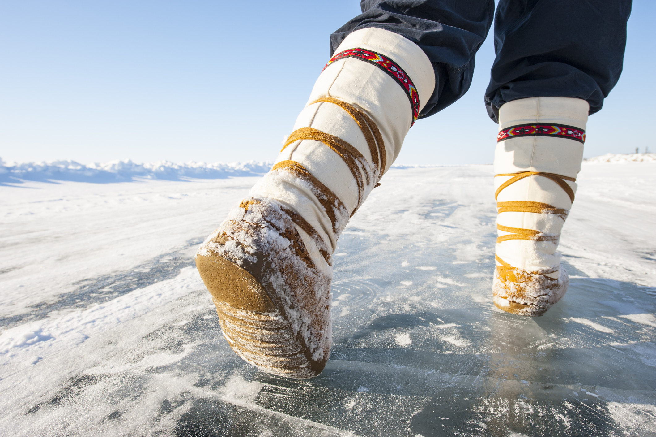 personne qui marche avec mukluks sur la glace